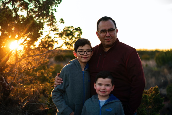 Picture of a father and two smiling sons